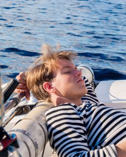 Homme dormant sur un voilier